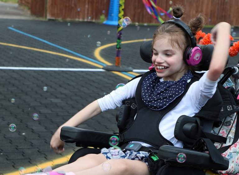 A smiling child in a wheelchair